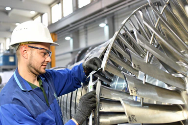 Ein Arbeiter an einer Turbine.