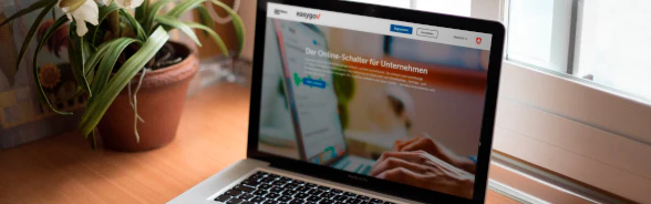 Ein Laptop steht auf einem Schreibtisch. Auf dem Bildschirm wird die Website EasyGov.swiss angezeigt.