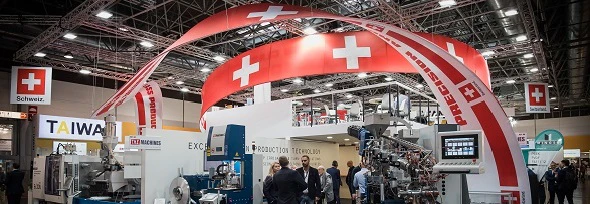 Menschen an Messeständen mit Schweizer Fahnen