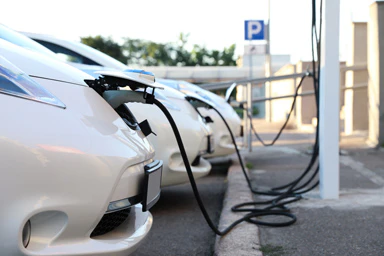 Drei Elektroautos laden ihre Batterien auf.