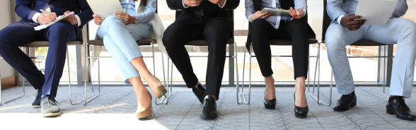 Männer und Frauen sitzen in einem Büro.