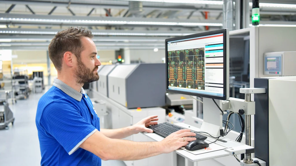 Ein Mann ruft in einer grossen Halle Daten auf einem Computer ab.