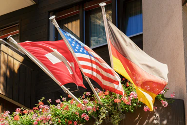 Die Flaggen der Schweiz, der USA und Deutschlands.