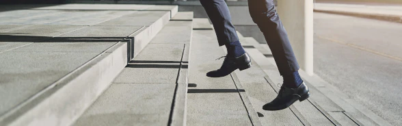 Ein Mann im Anzug läuft eine Treppe hoch.