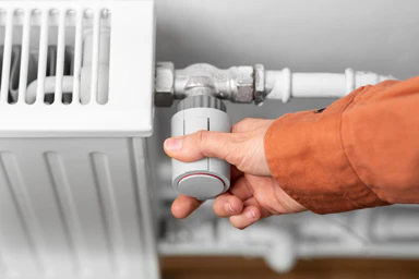 A person turns off the heating.