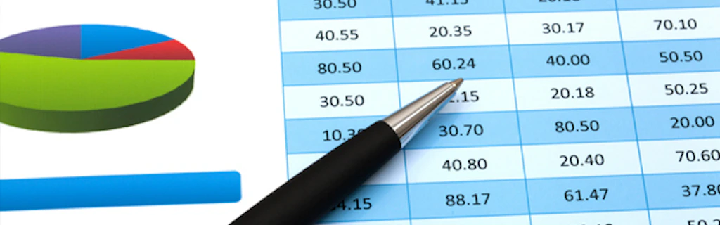 Pen lying on a sheet of paper containing figures and graphs
