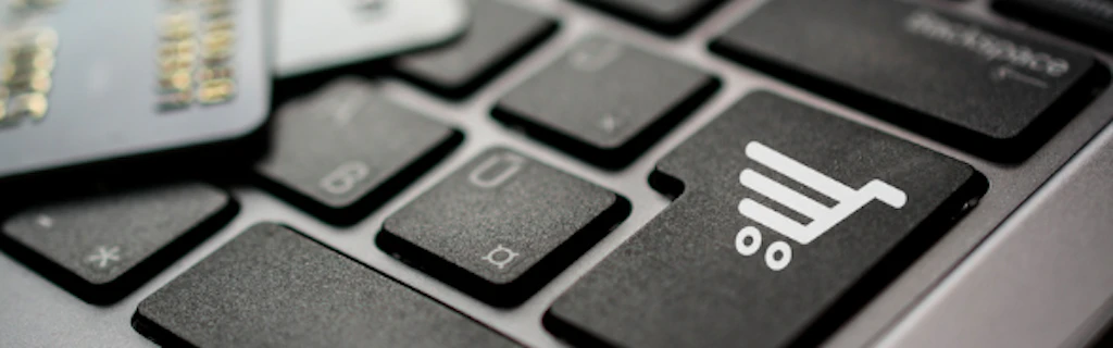 Close-up of a computer keyboard key with a shopping cart on it.