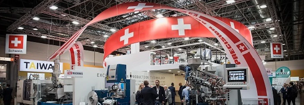 People at exhibition stands with Swiss flags