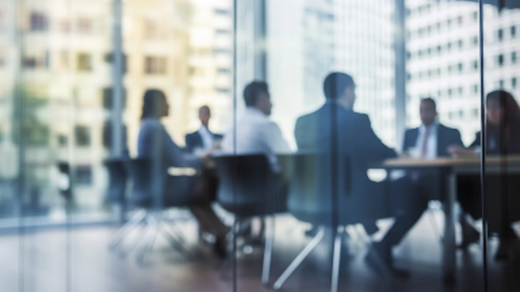 People in a meeting behind a glass window.
