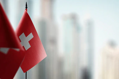 Two Swiss flags on a blurred background.