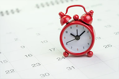A small red alarm clock.