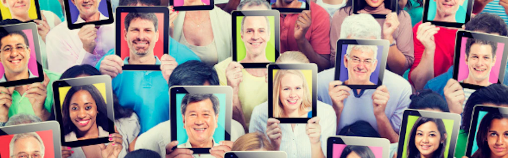A group of people holding on their forehead touchpads displaying the face of other people