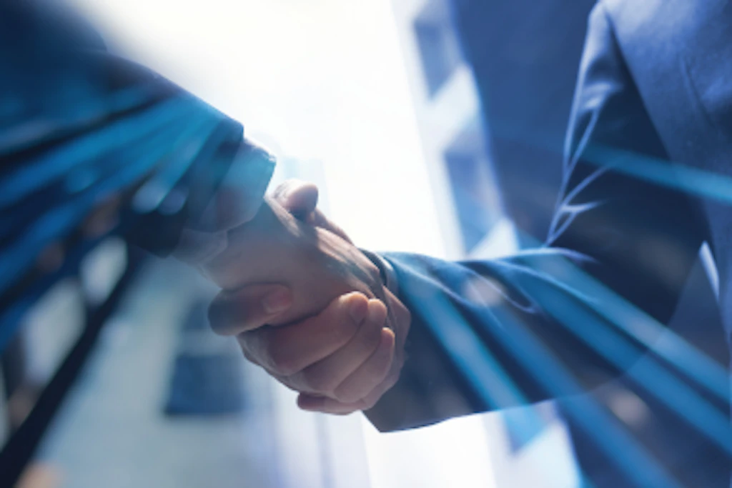 A handshake with buildings in the background.