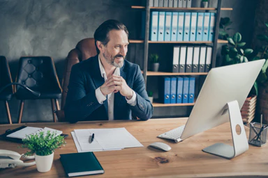 A man smiling in his office.