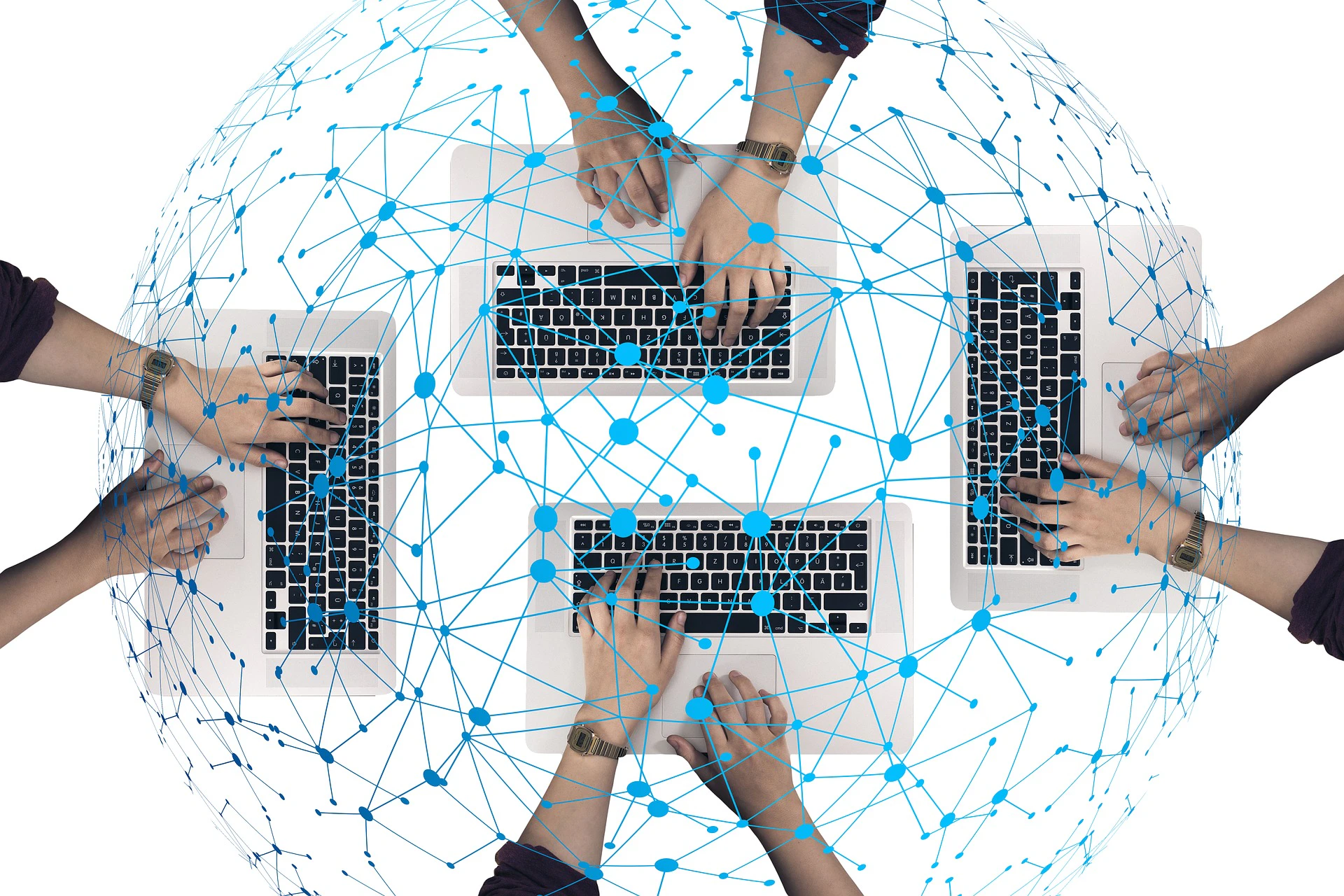 Hands of four people working on four different computer keyboards