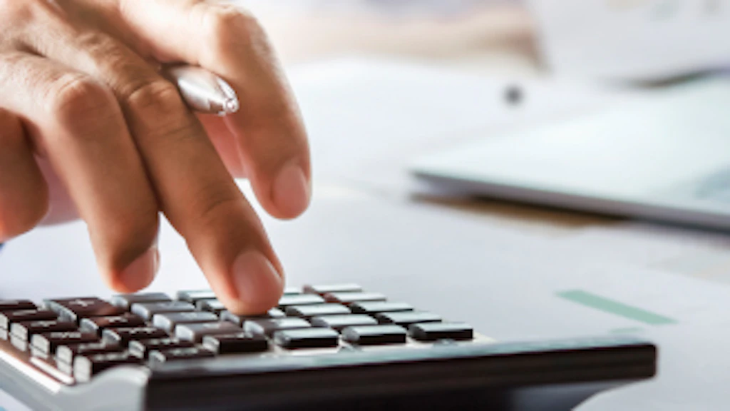 A man performs calculations using a calculator