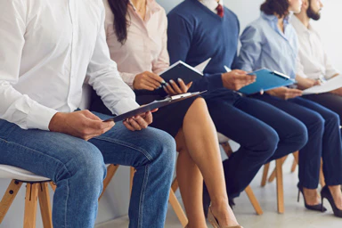 Several people sitting in a row in a professional setting.