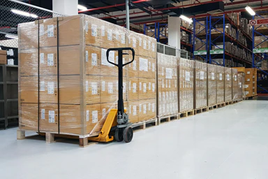 A forklift and freight cartons in a hangar.