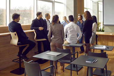 Plusieurs employés discutent dans une salle de réunion.