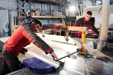Deux hommes travaillent le bois.
