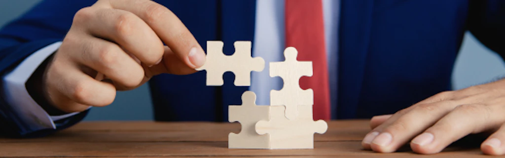Un homme en costume ajoute une pièce à un puzzle.