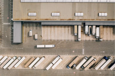 Plusieurs camions d’exportation parqués devant un hangar.