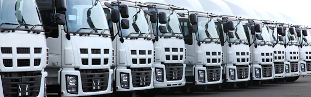 Rangée de camions blancs sortant de l'usine