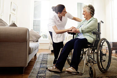 Une professionnelle de santé discute avec une personne en fauteuil roulant.