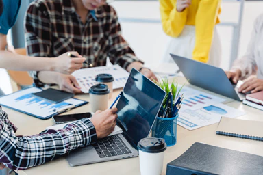 Des personnes analysent des graphiques et consultent leur ordinateur.