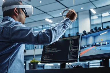 Un homme avec un casque de réalité virtuelle joue sur son ordinateur.