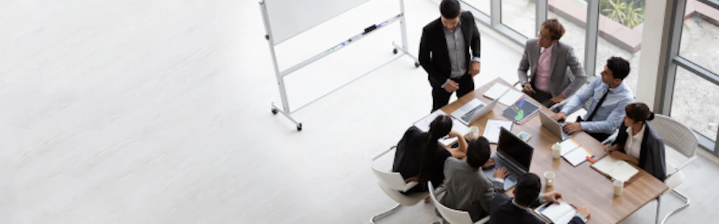 Un groupe de personnes se tient autour d'une table lors d'une réunion de travail.