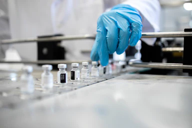 Un scientifique devant des fioles contenant des vaccins.