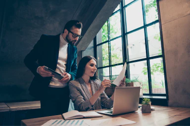 Un homme et une femme consultent un document professionnel.