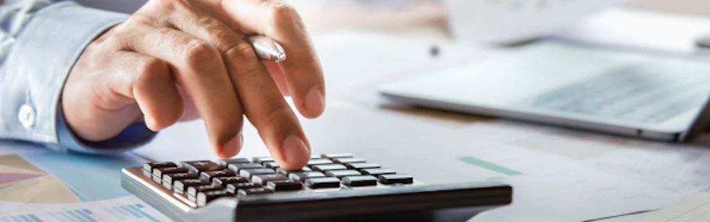 Un homme effectue des calculs à l'aide d'une calculatrice.