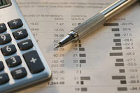 Gros plan d'un stylo et d'une calculatrice posés sur une feuille de calcul