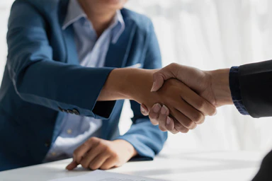 Deux personnes se serrent la main à un bureau.