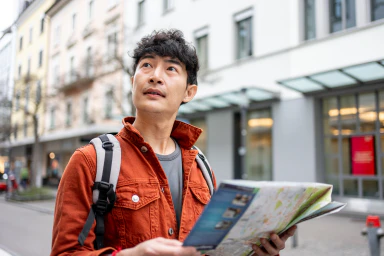 Un uomo consulta una cartina in mezzo a una strada.