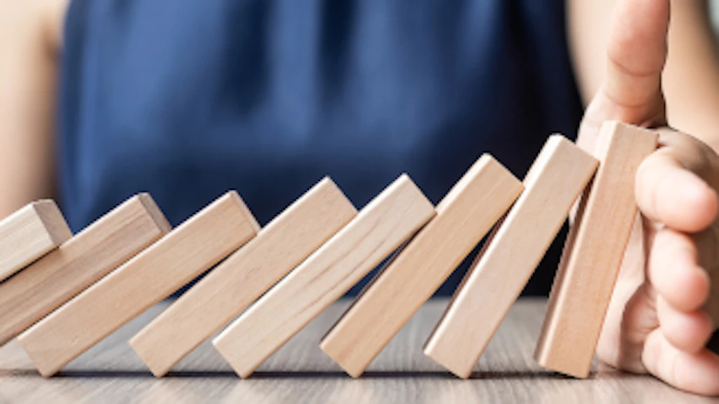 Una donna blocca un domino.