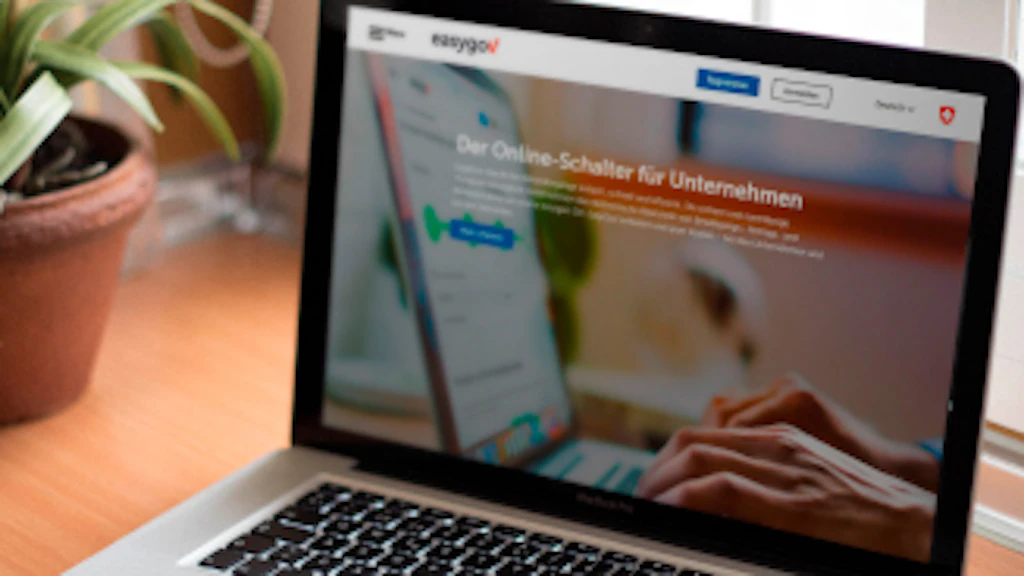 Un computer portatile poggia su una scrivania. Sullo schermo appare il sito EasyGov.swiss.