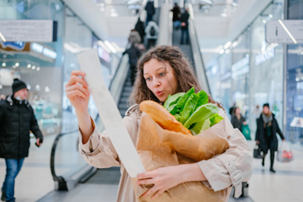 Una donna al supermercato con uno scontrino molto lungo.