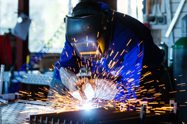 Un lavoratore metallurgico effettua una saldatura.
